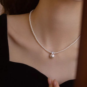 Luminous pearl pendant choker necklace with delicate pearl strand and crystal accent.