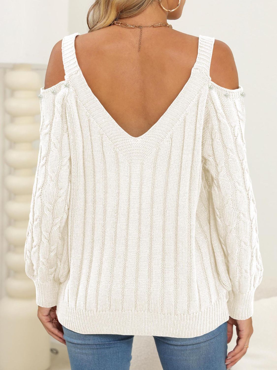 White cable knit cold shoulder sweater with button details and V-neck