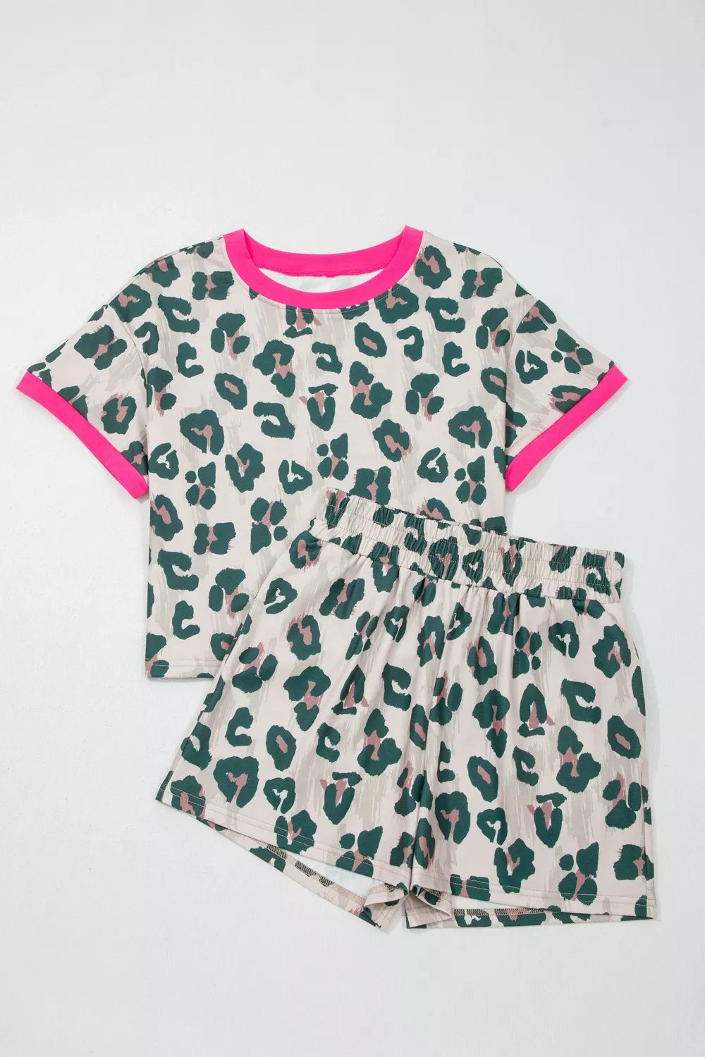 Leopard print pajama set with pink trim, featuring a short sleeve top and elastic waist shorts.