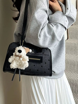 Black polka dot shoulder bag with a fluffy dog charm and gold hardware.