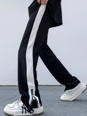 Black sweatpants with white side stripe and ankle zippers.