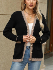 Black knit cardigan with contrast trim and gold buttons, featuring pockets.