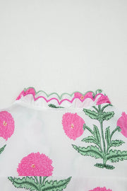 White cotton blouse with vibrant pink floral print and scalloped pink and green trim neckline.