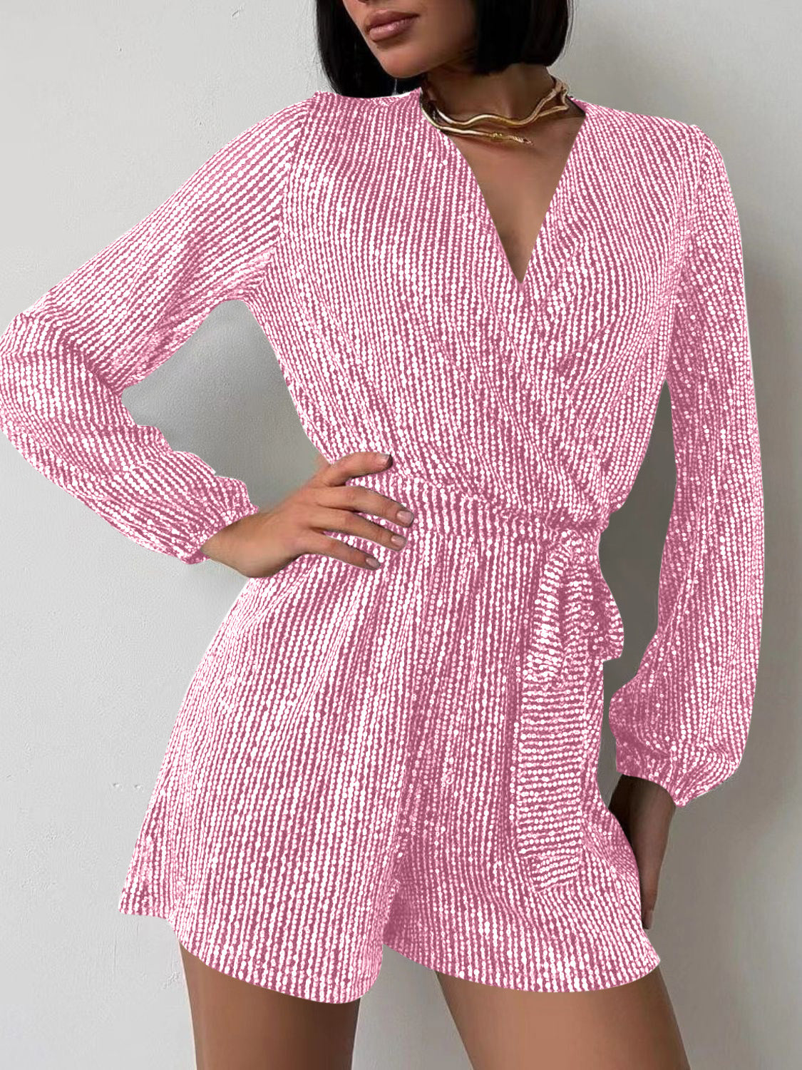 Pink sequin wrap romper with blouson sleeves and tie waist
