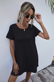 Black relaxed tee dress with short sleeves and crew neck, featuring side pockets.