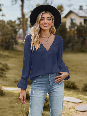 Navy textured blouse with lace trim neckline and bell sleeves.