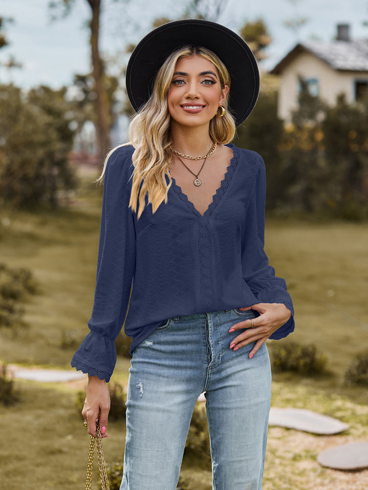 Navy textured blouse with lace trim neckline and bell sleeves.