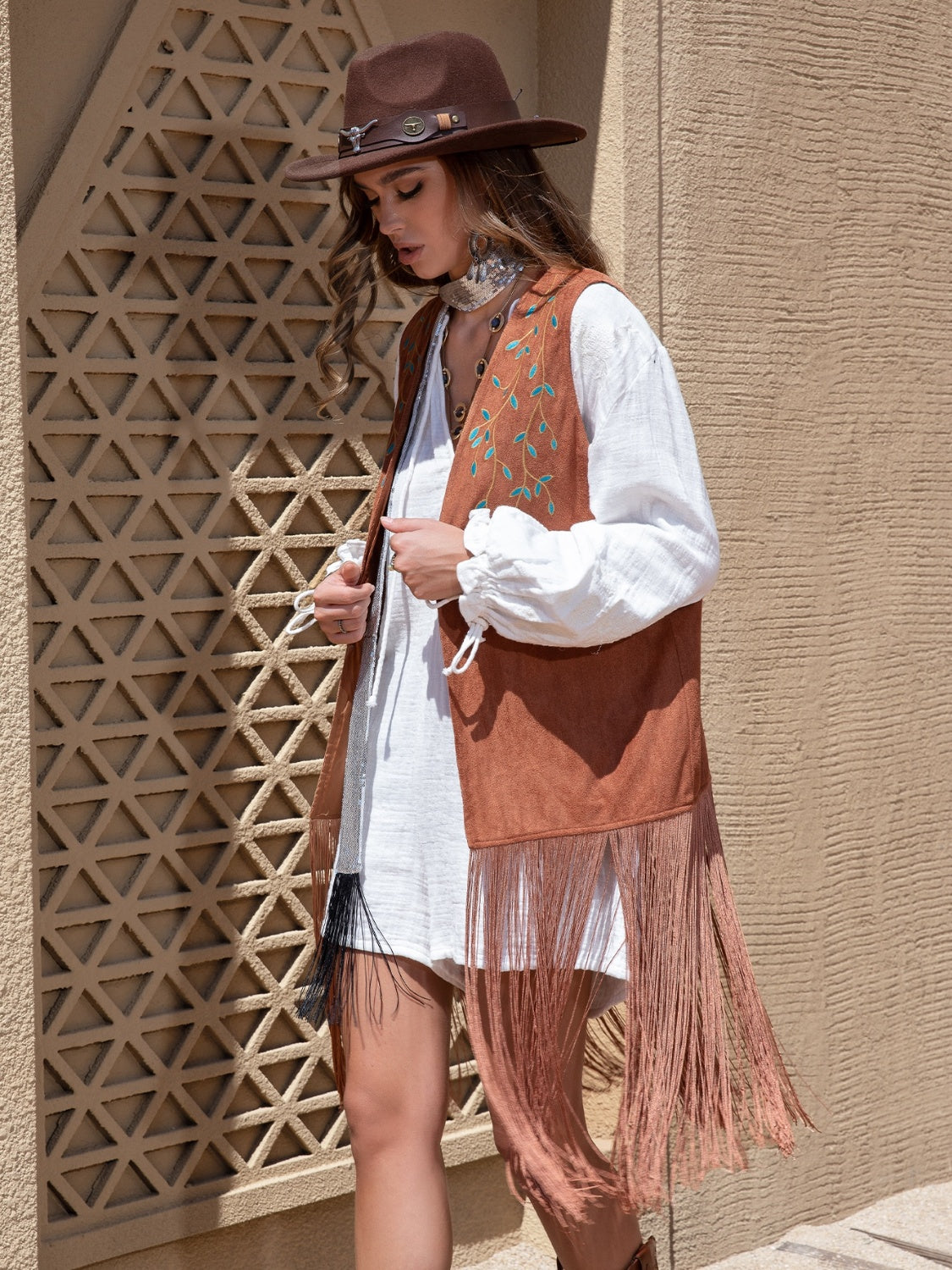Terracotta faux suede vest with embroidered leaf detail and long fringe.
