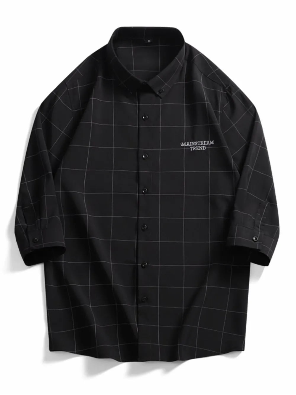 Black oversized plaid button-down shirt with embroidered text detail.