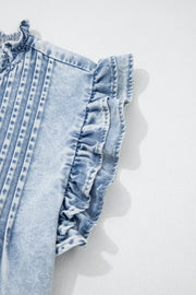 Light wash denim top with ruffled cap sleeves and pintuck details.