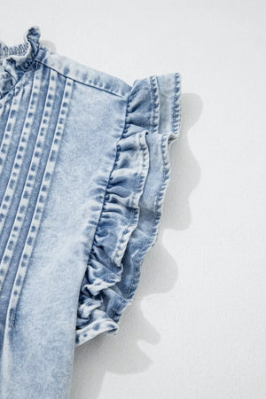 Light wash denim top with ruffled cap sleeves and pintuck details.