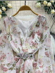 Floral wrap mini dress in light blue with V-neck, long sleeves, cinched waist, and ruffle hem.