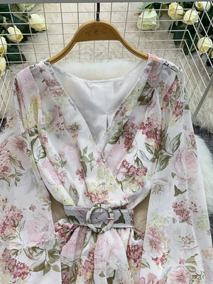 Floral wrap mini dress in light blue with V-neck, long sleeves, cinched waist, and ruffle hem.