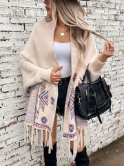 Cream Aztec fringe knit cardigan with colorful geometric pattern and fringe detail.
