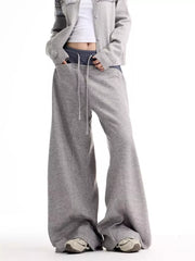 Grey wide-leg sweatpants with drawstring and pockets, styled with a cropped cardigan.