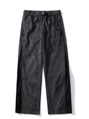 Black utility-inspired wide-leg joggers with mesh side panels and buckle belt.