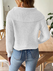 White ribbed knit sweater with shawl collar and long sleeves, styled with jeans.