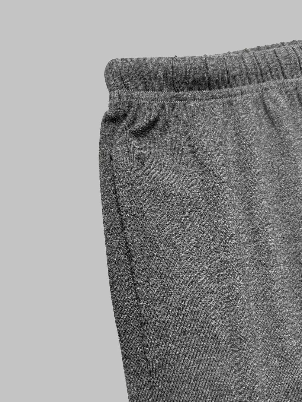 Grey drawstring pants with elastic waistband and side pocket detail.