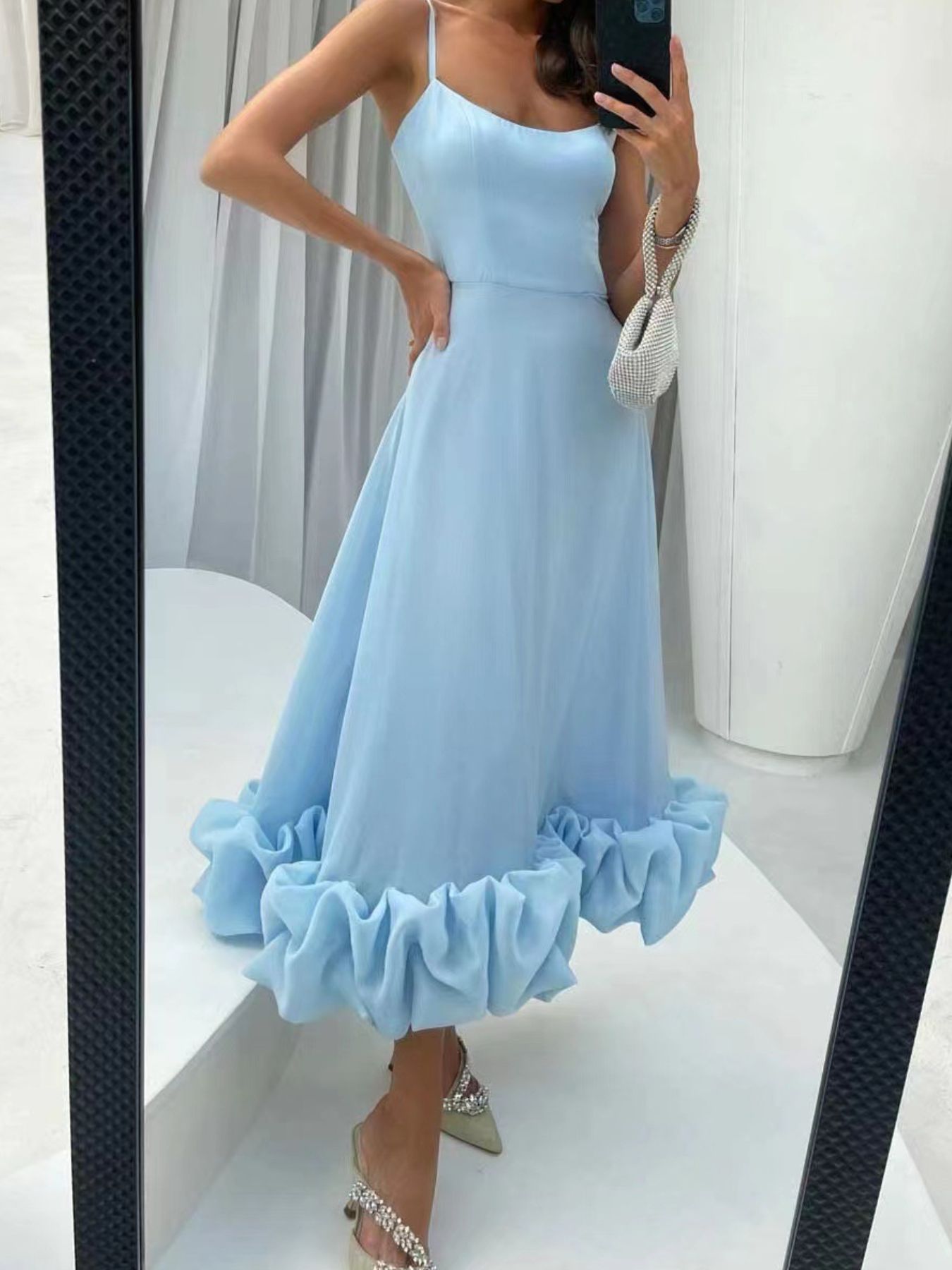Light blue midi dress with spaghetti straps and a ruffled hem.