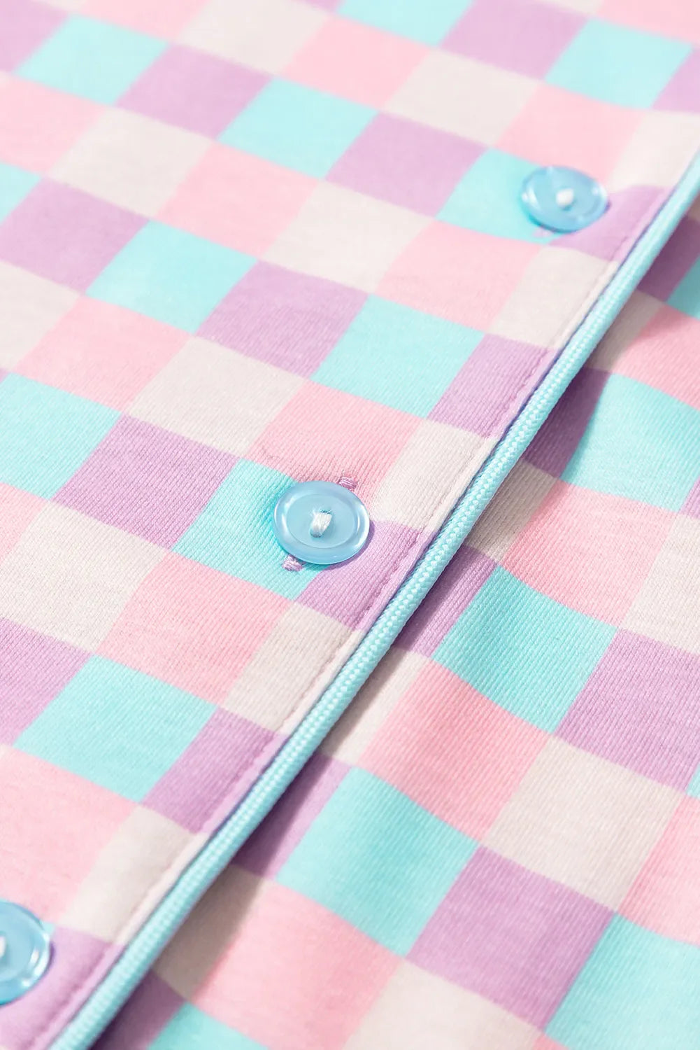 Pastel checkered pajama set with blue buttons and piping