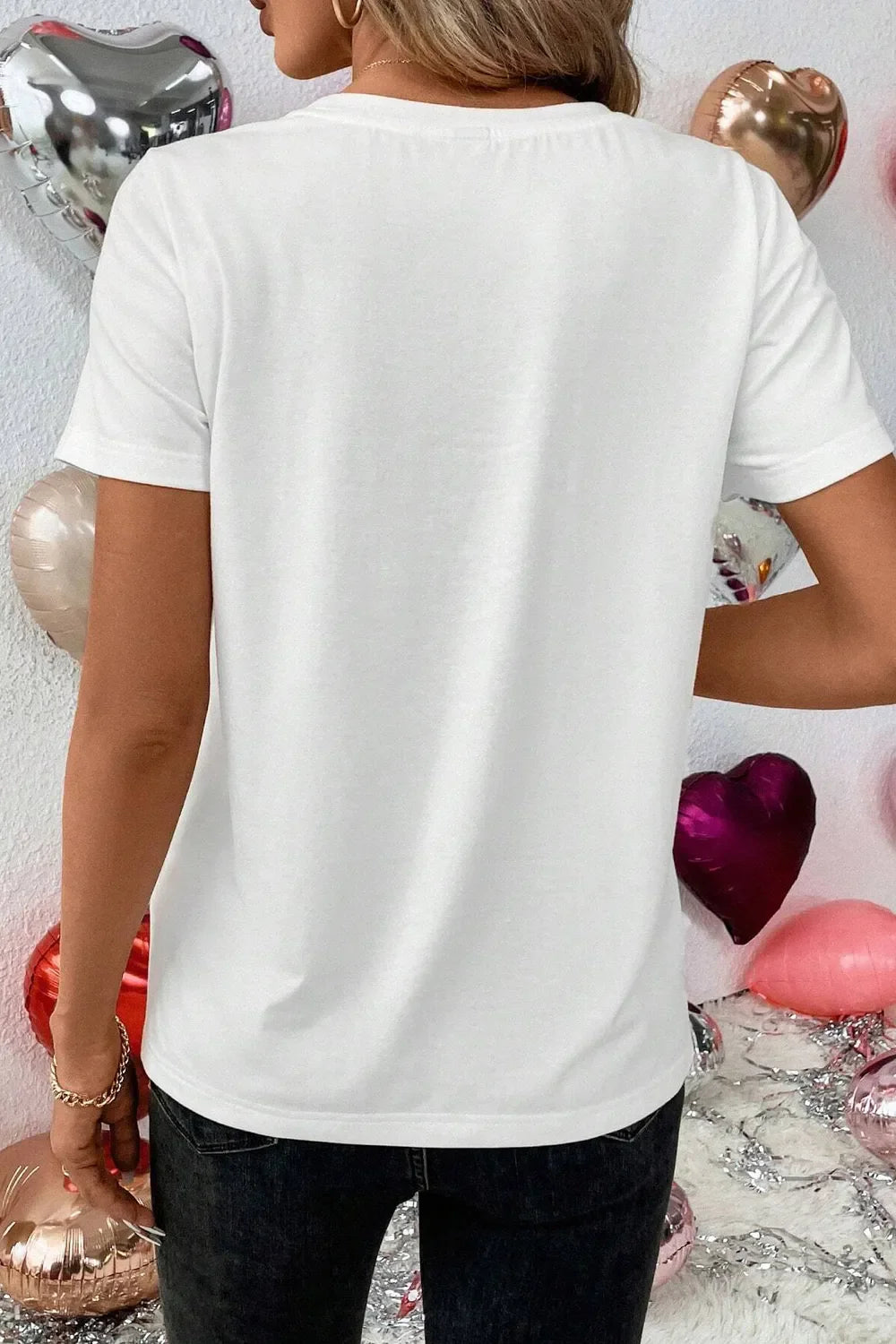 White graphic t-shirt with short sleeves and a crew neck, styled casually.