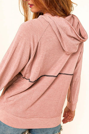 Dusty pink knit hoodie with contrast black stitching detail across the back.