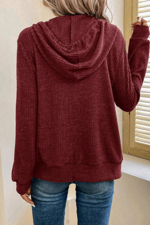 Burgundy textured ribbed knit hoodie with a drawstring hood and cuffed sleeves.