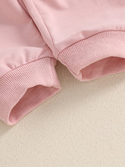 Pink cotton baby outfit set with ribbed cuffs and hem detail.