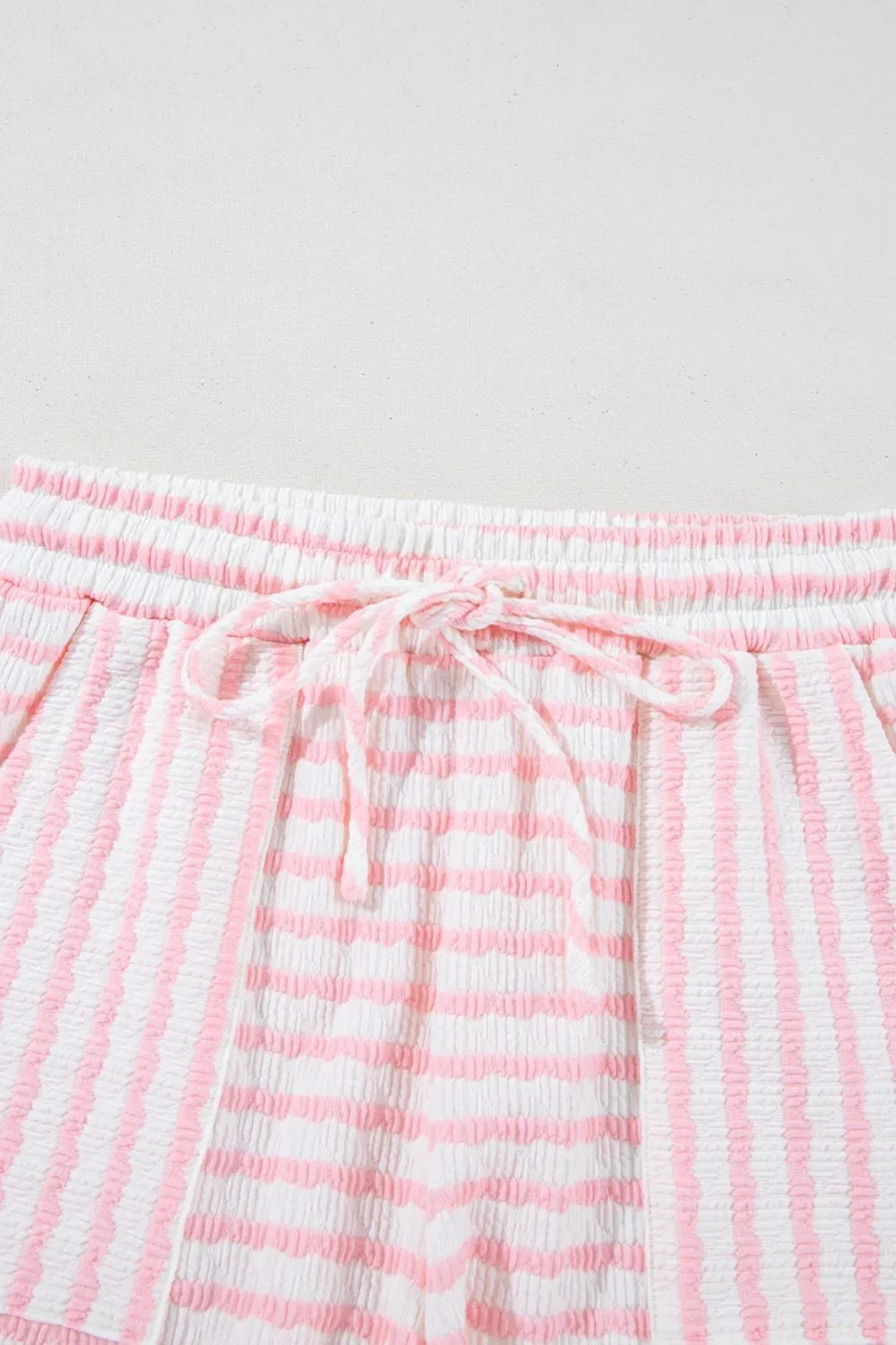 Textured stripe lounge shorts in blush pink and white with drawstring waist.
