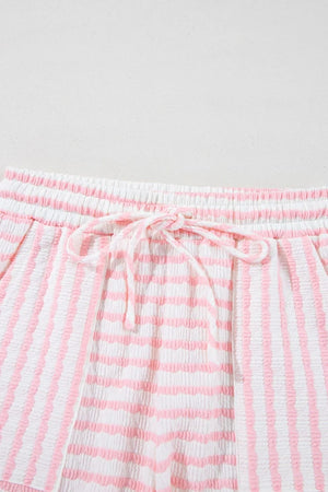 Textured stripe lounge shorts in blush pink and white with drawstring waist.