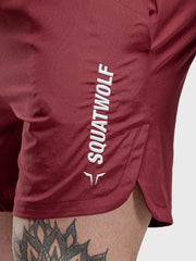Burgundy performance shorts with split hem and white logo detail
