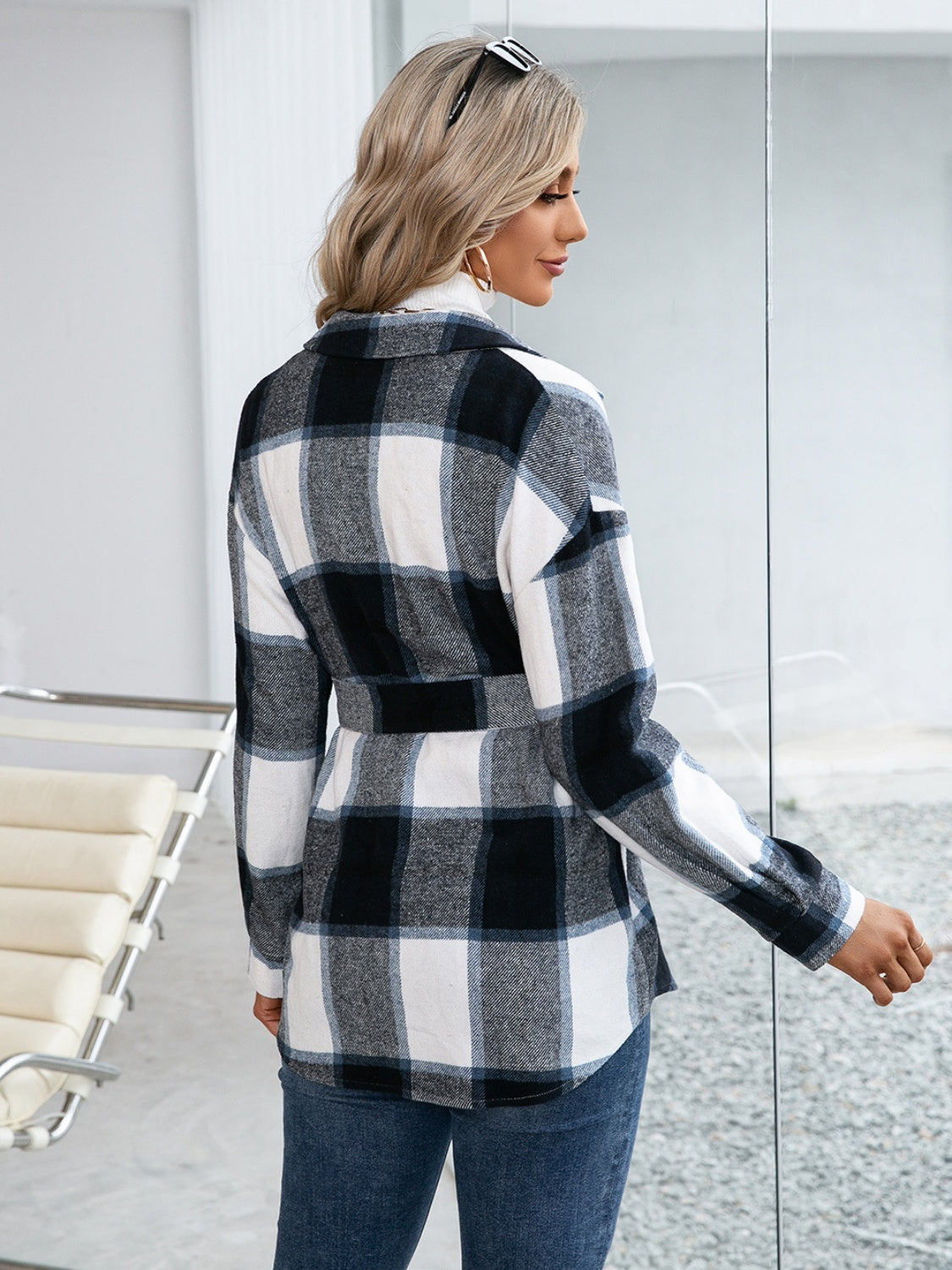 Black belted plaid overshirt with patch pockets and button-down front, styled casually.