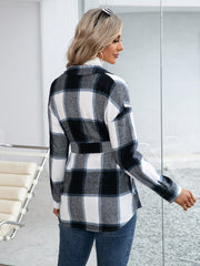 Black belted plaid overshirt with patch pockets and button-down front, styled casually.