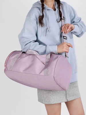 Pastel purple barrel duffle bag with zippered pocket and gray straps.