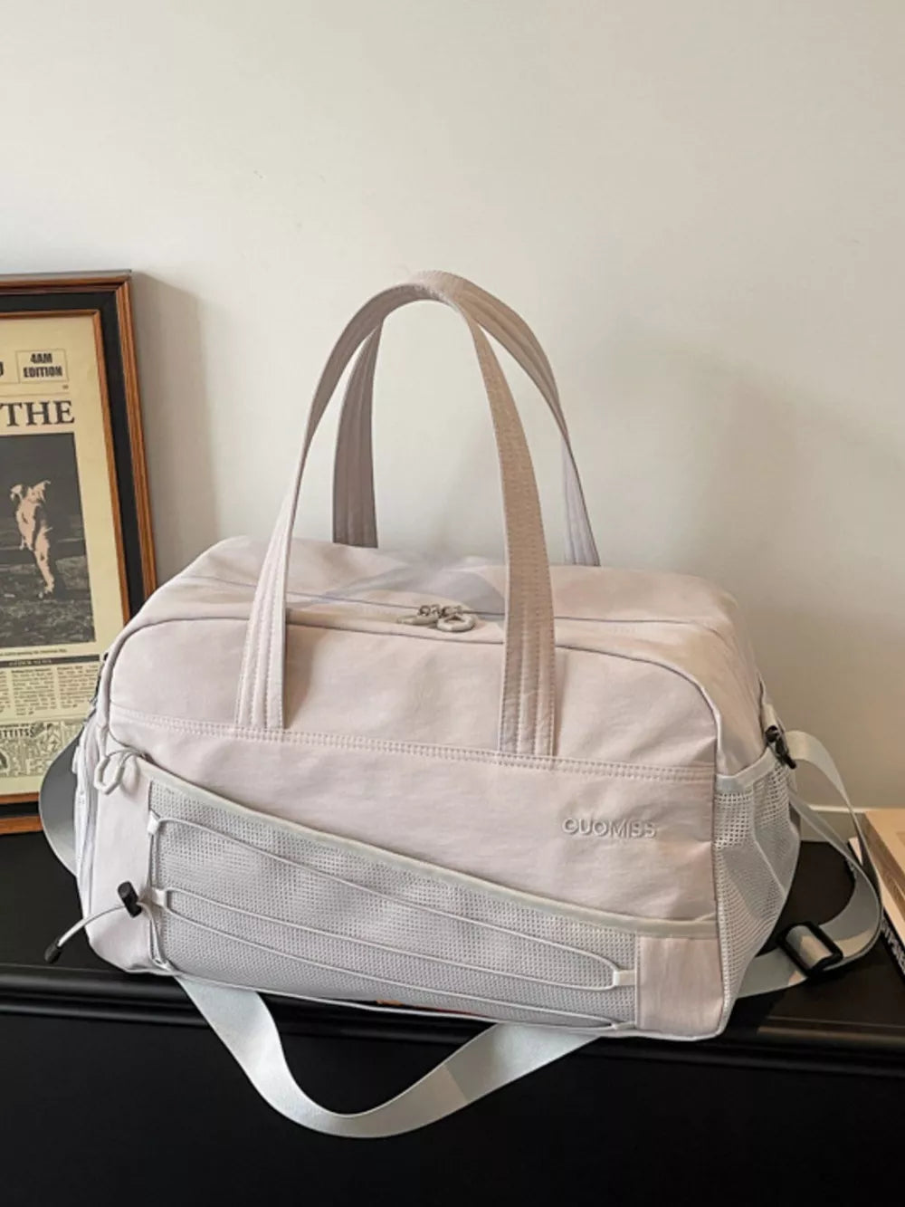 Grey nylon travel organizer bag with adjustable strap and mesh pocket details.
