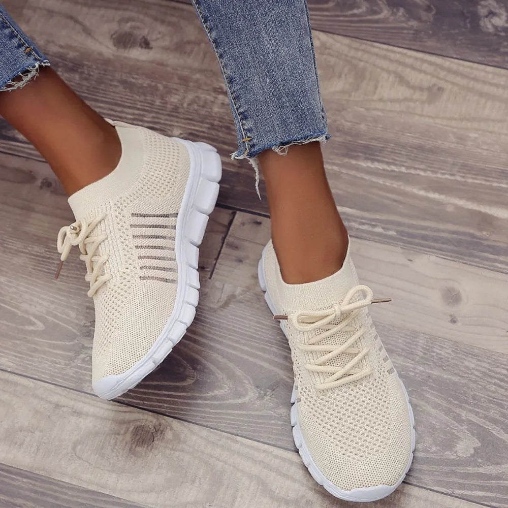 Beige knit runner sneakers with ribbed detail and white soles.