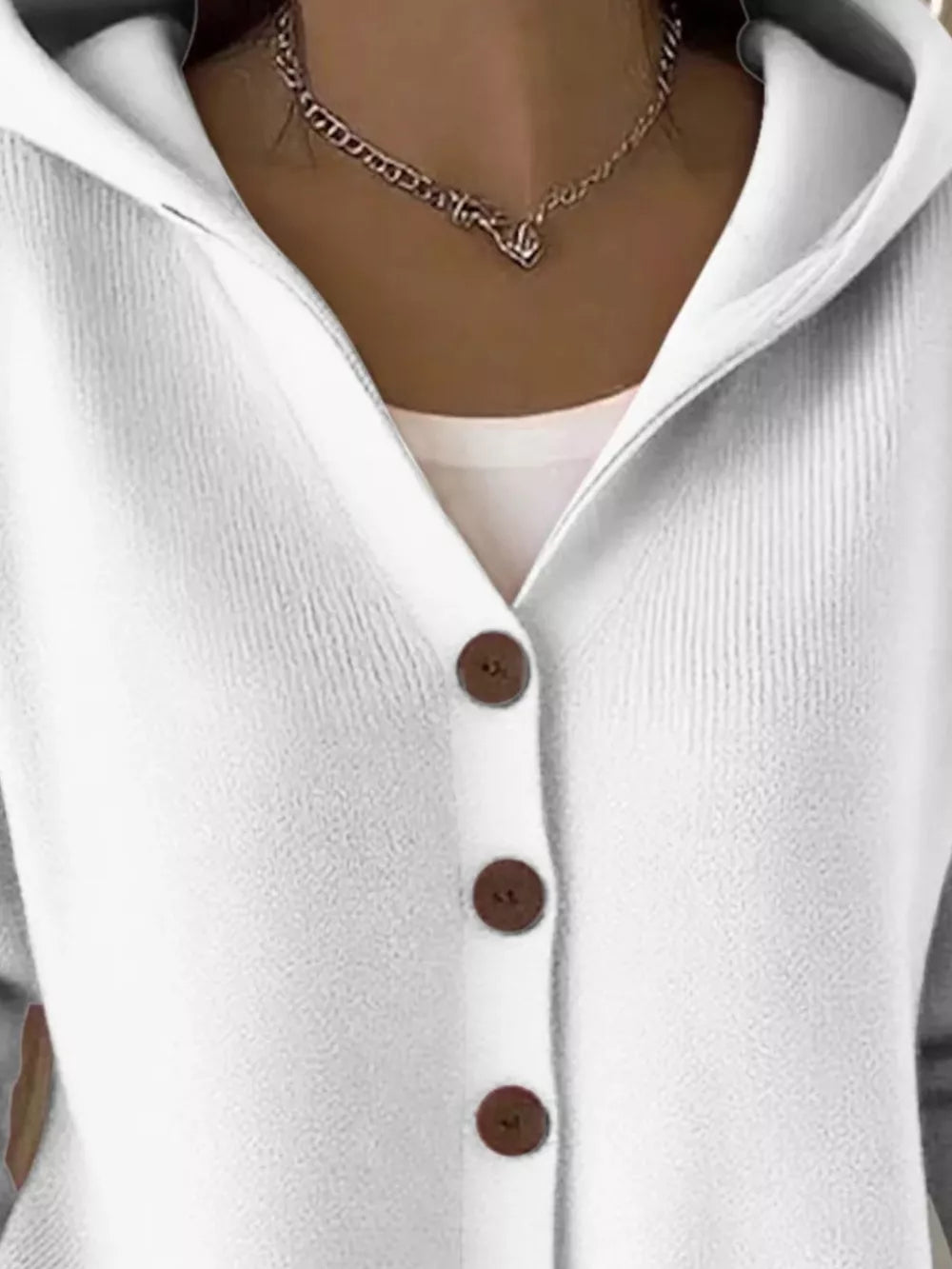 White hooded knit cardigan with button front and ribbed texture.