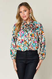Silk tie-neck blouse with abstract ikat print and button front.