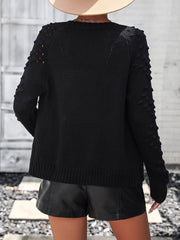 Black acrylic cardigan with textured sleeves and open knit detail on shoulders.