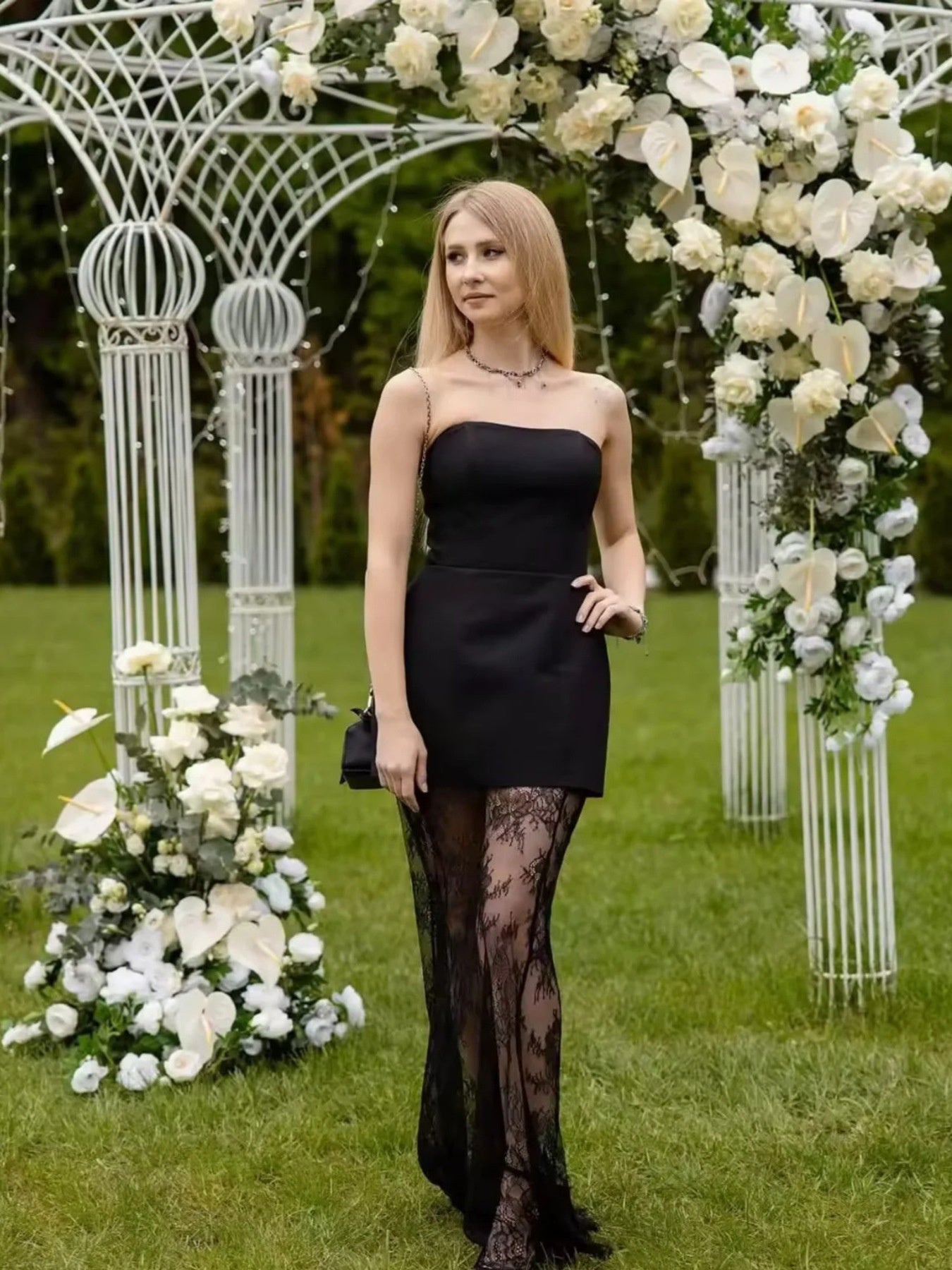 Black strapless mini dress with lace trim and sheer lace skirt overlay.
