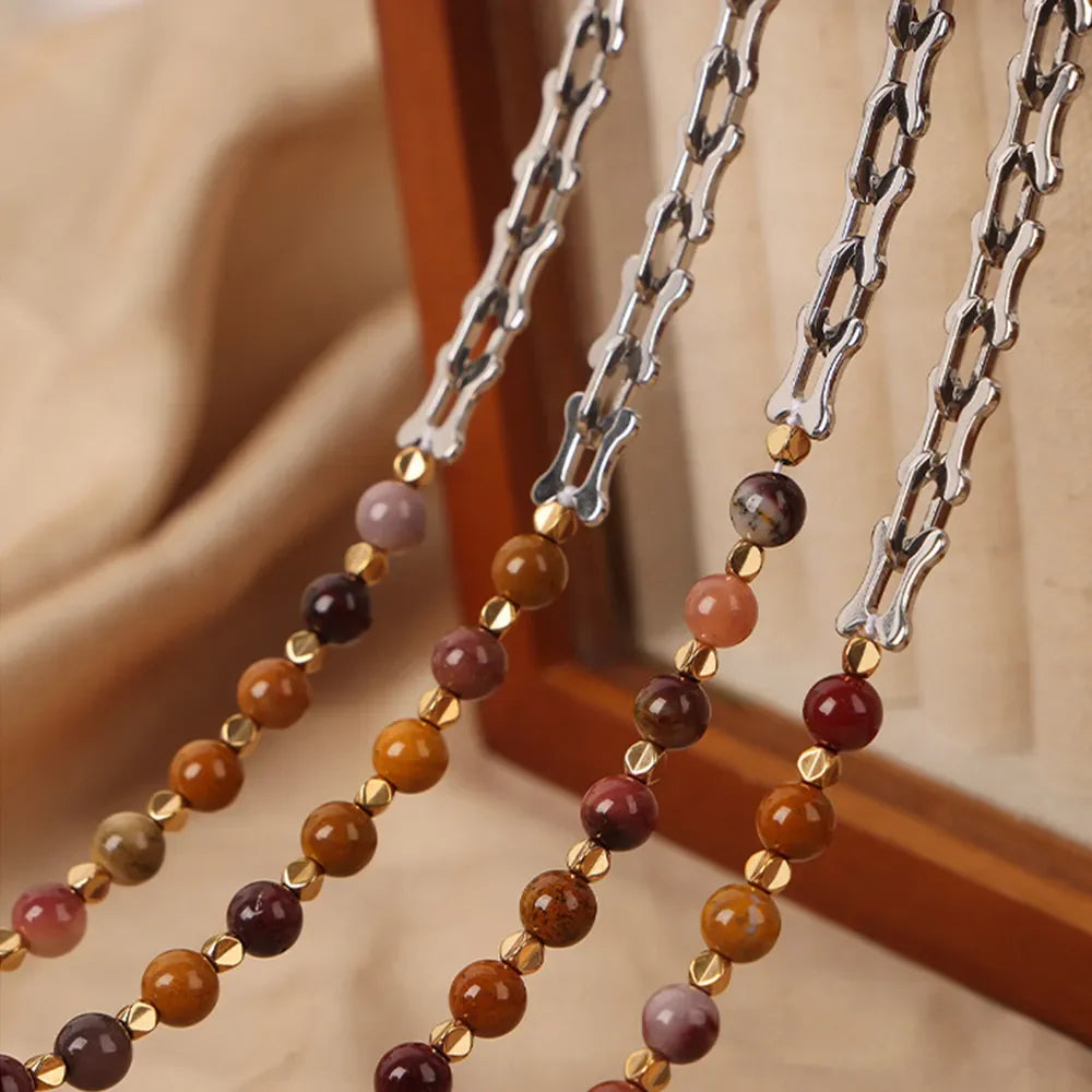 Silver asymmetrical chain necklace with mixed stone beads and gold accents.