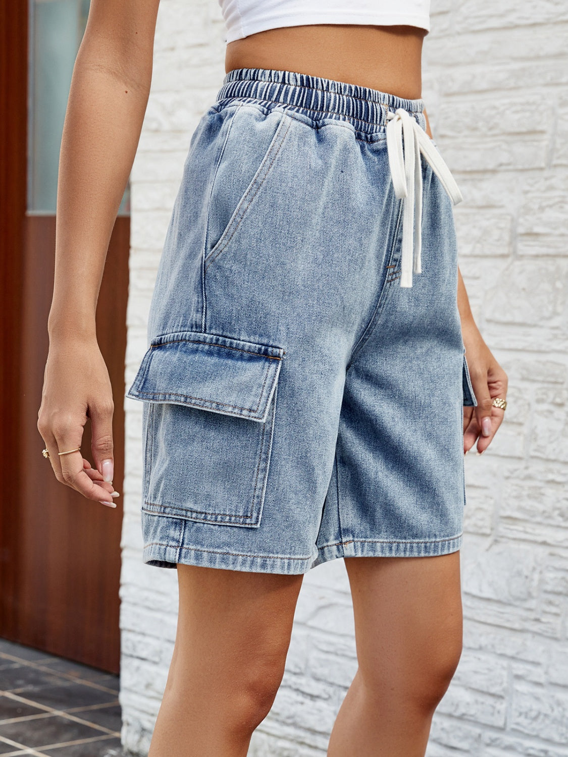 Denim cargo shorts in dusty blue with drawstring waist and utility pockets.