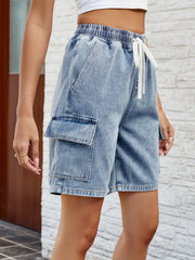 Denim cargo shorts in dusty blue with drawstring waist and utility pockets.