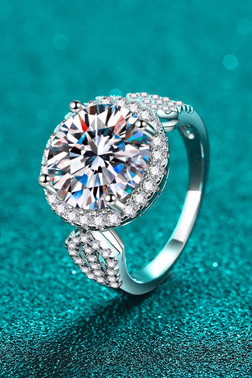 Silver halo moissanite ring with sculpted band and pavé accents.