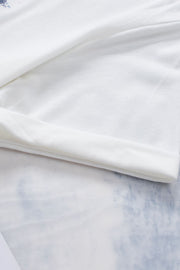 White graphic tee with floral accents and rolled sleeves.