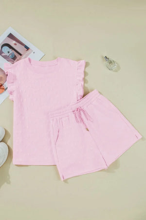 Blush pink loungewear set with embossed bow pattern, ruffle sleeves, and drawstring shorts.