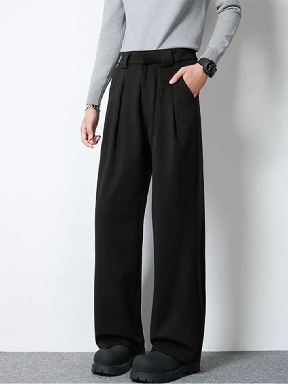 Men's black wide-leg pleated trousers with a relaxed fit and side pockets.