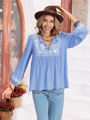 Misty Blue embroidered yoke blouse with gathered bodice, tie neck, and embroidered sleeves.
