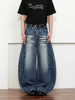 Belted wide leg jeans in dark blue denim with a balloon silhouette and distressed details.