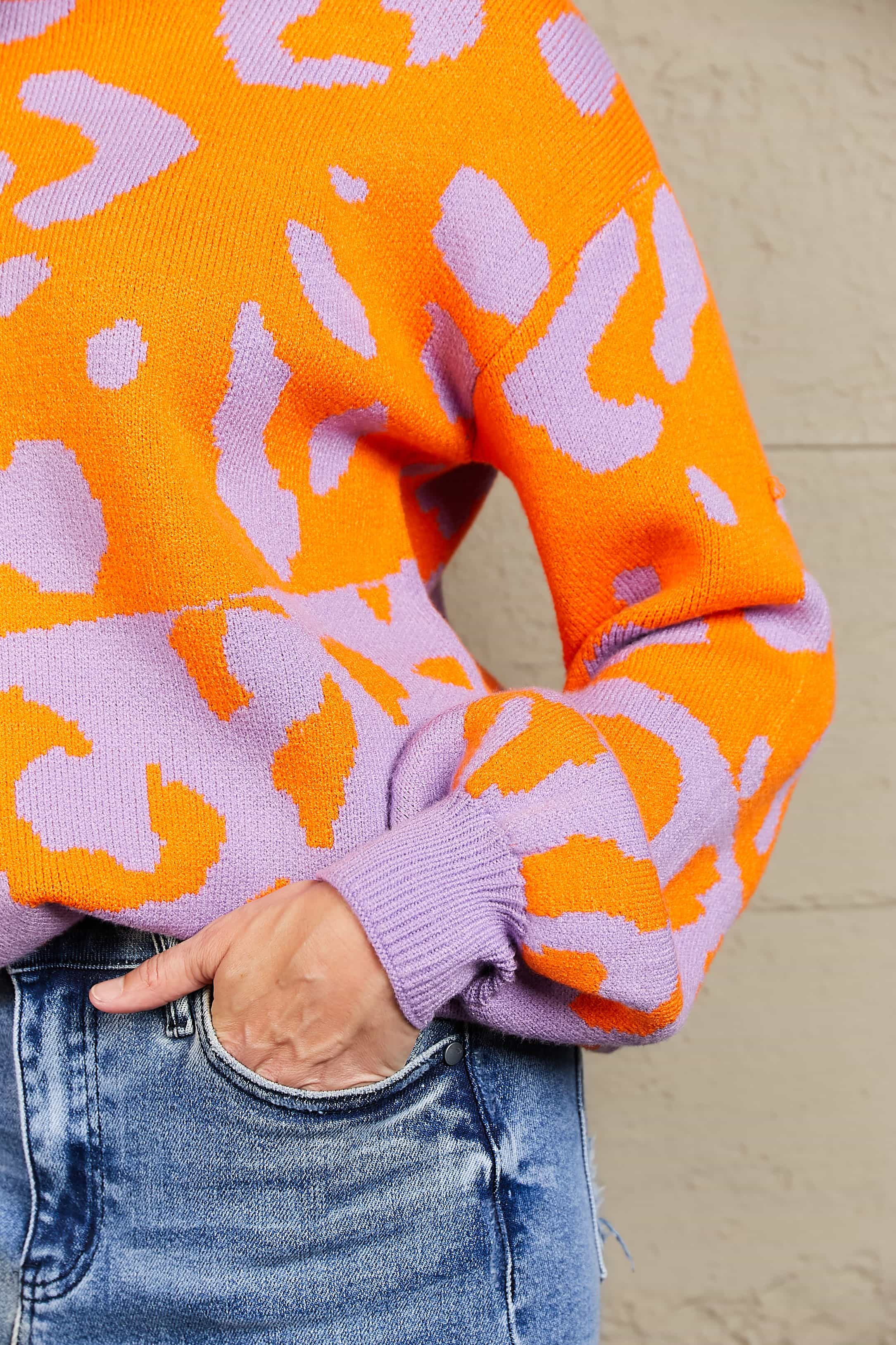 Colorblock leopard print acrylic sweater with balloon sleeves in orange and lavender.